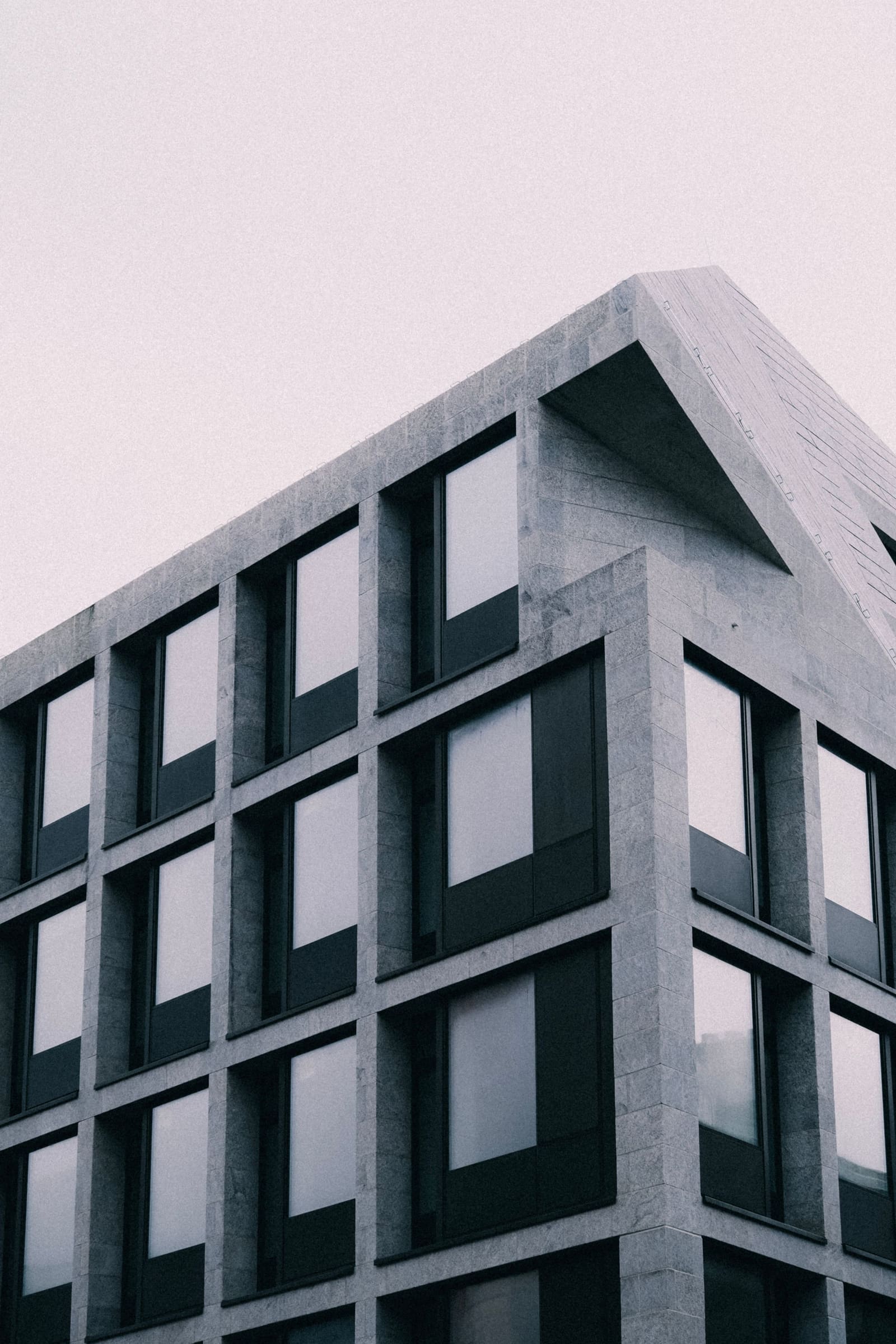 Stone facade of an institutional building, a strict grid of windows